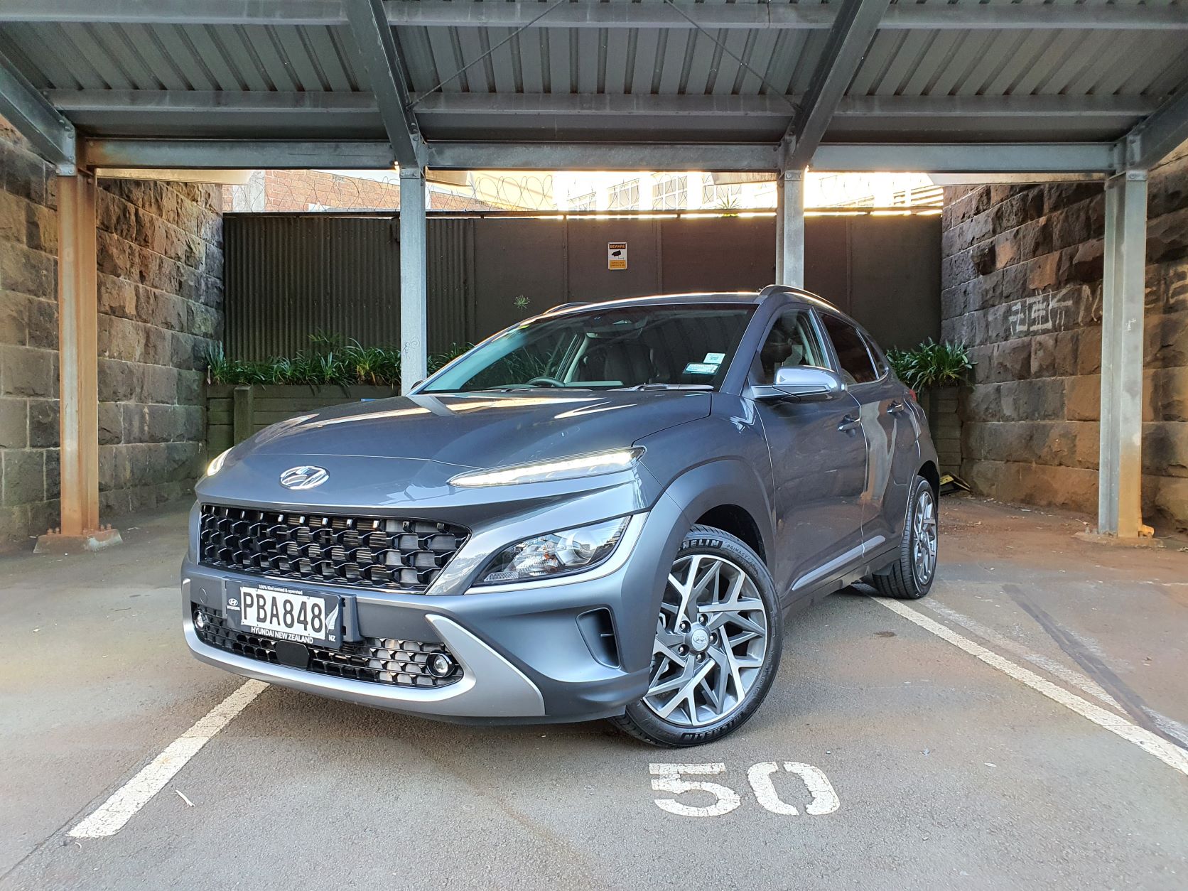 Front three quarters view of the new 2022 Hyundai Kona Hybrid in bluish gray