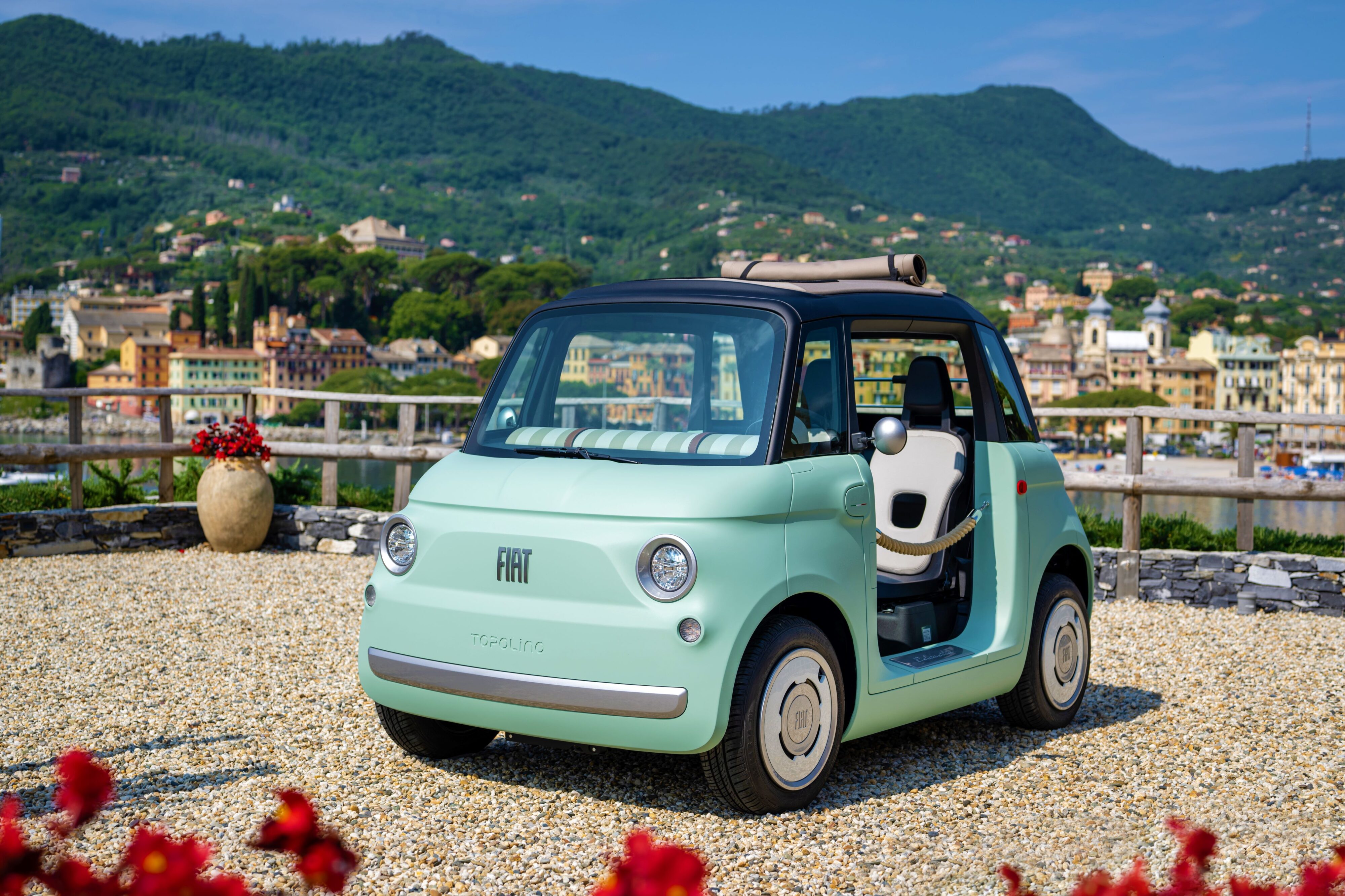 A picture of a mint green colour Fiat Topolino on the Italian coast
