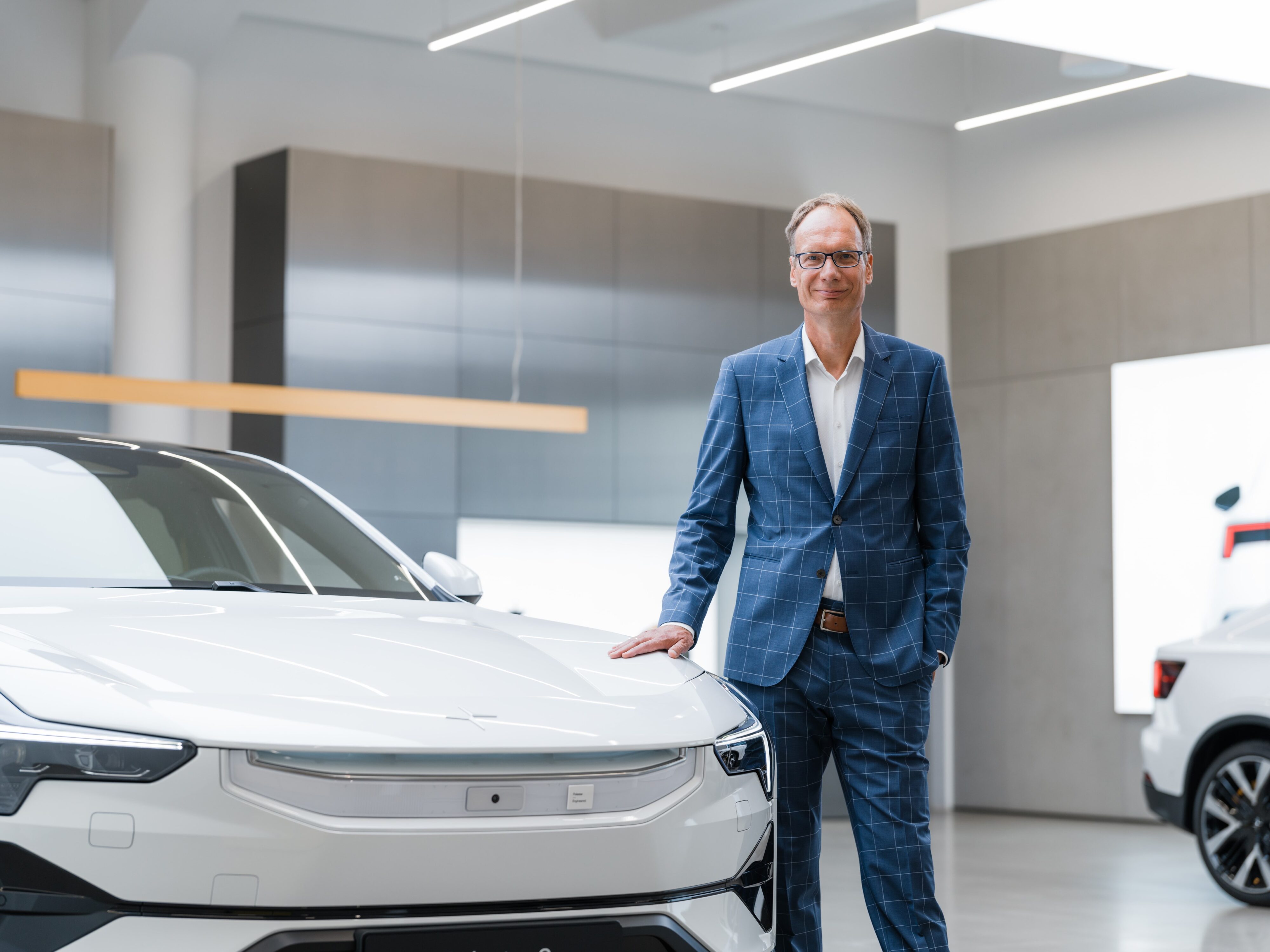 Michael Lohscheller standing by a white Polestar EV.