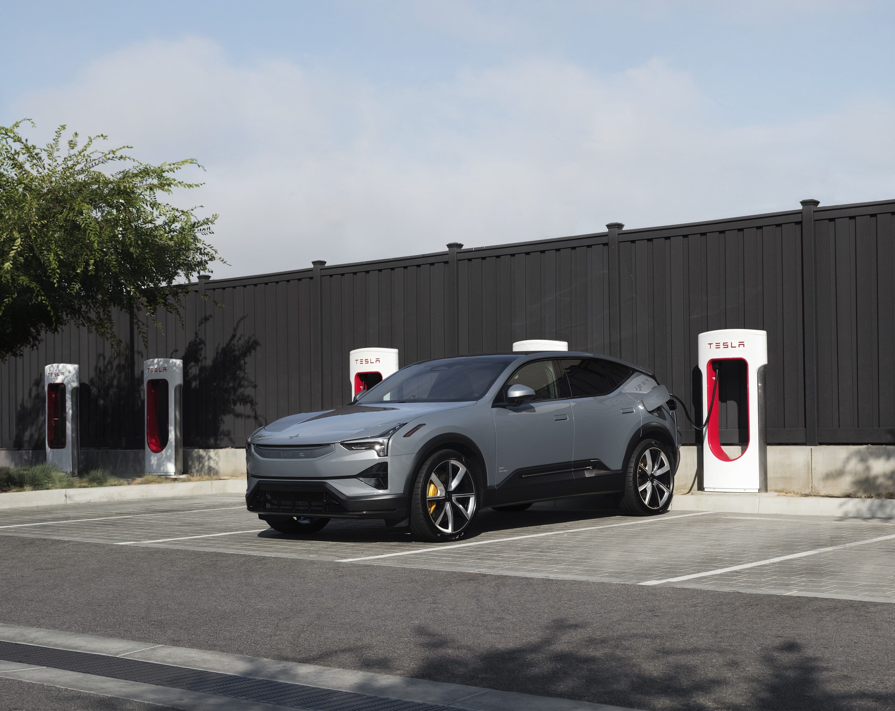 A Polestar car in front Tesla Superchargers