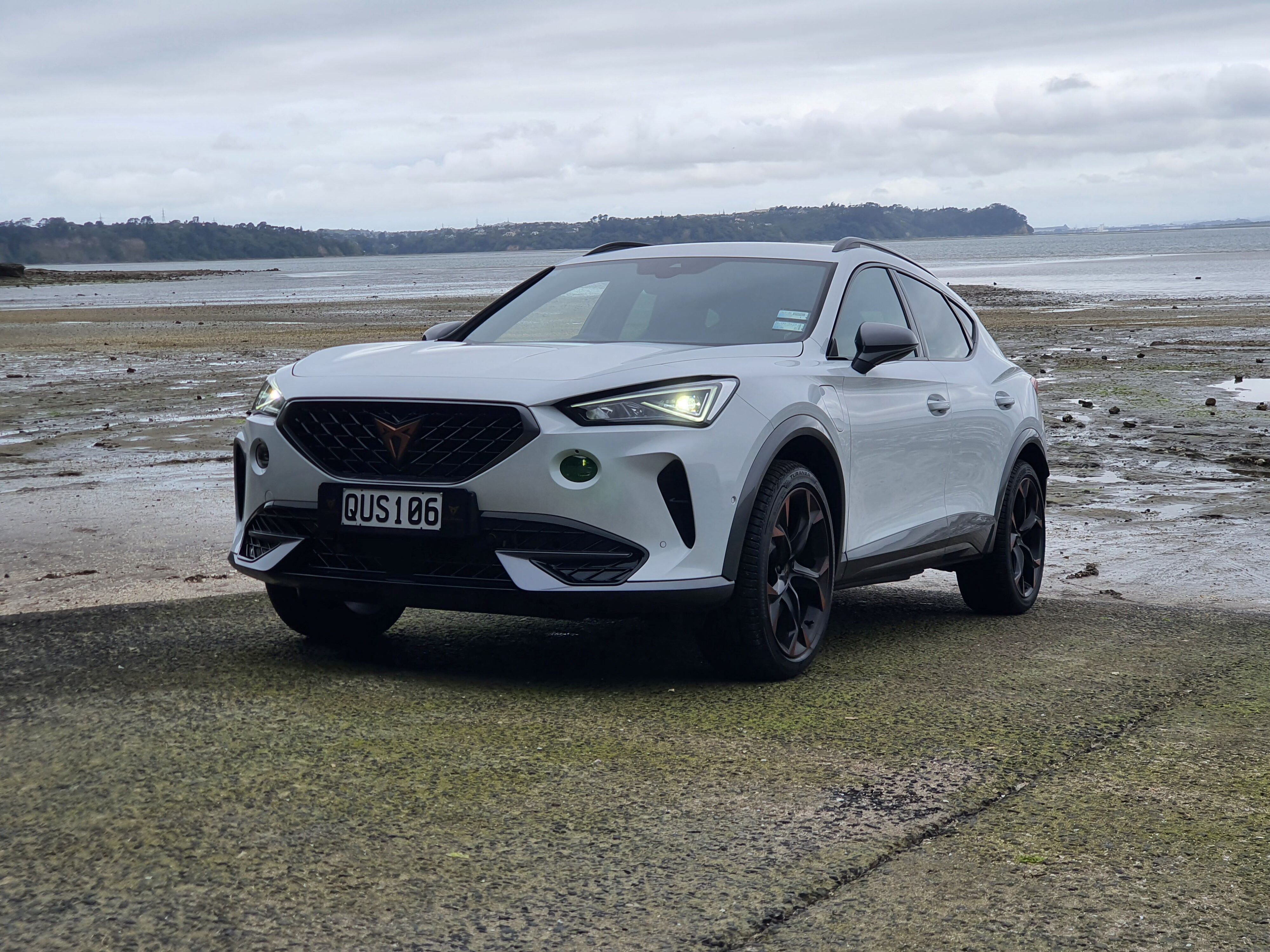 Front three quarters view of a 2024 Cupra Formentor V e-Hybrid in white on a boat ramp.