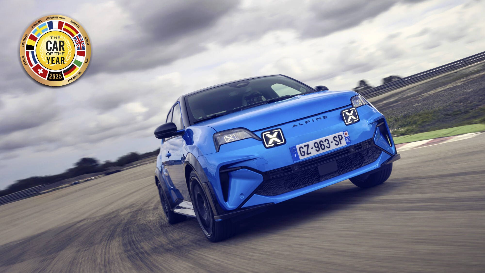 A blue Alpine A290 in motion with the European Car of the Year Award stamp in the top left of the image.