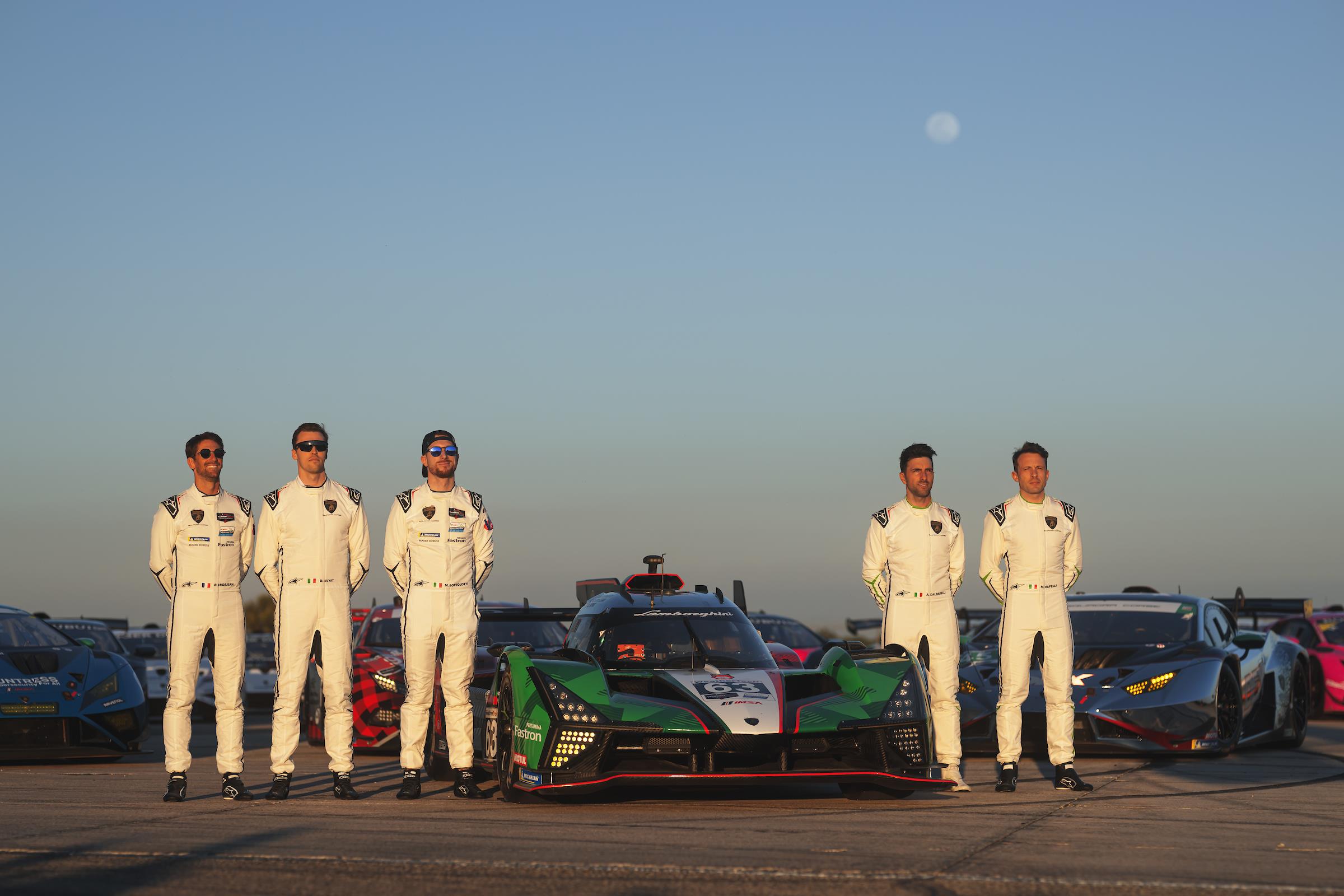 The Lamborghini Squadra Corse drivers pose with a range of Lamborghini racecars.