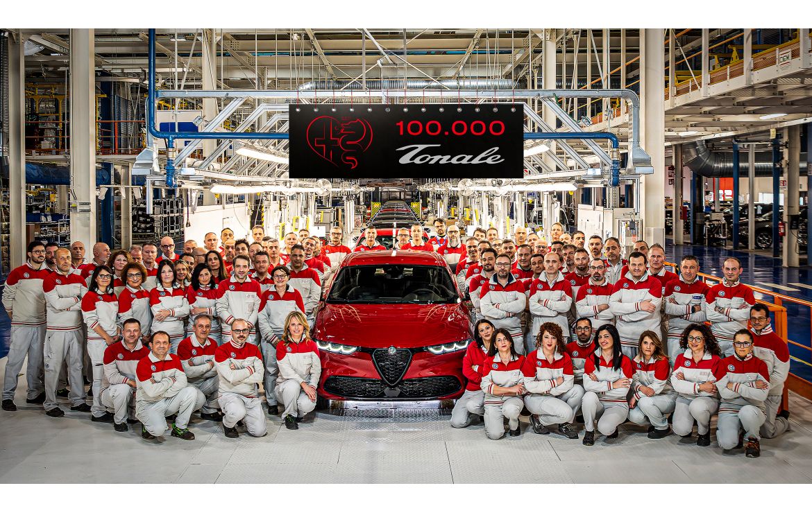 A photo of the team at Pomigliano d'Arco posing with the 100,000th Alfa Romeo Tonale in Red.