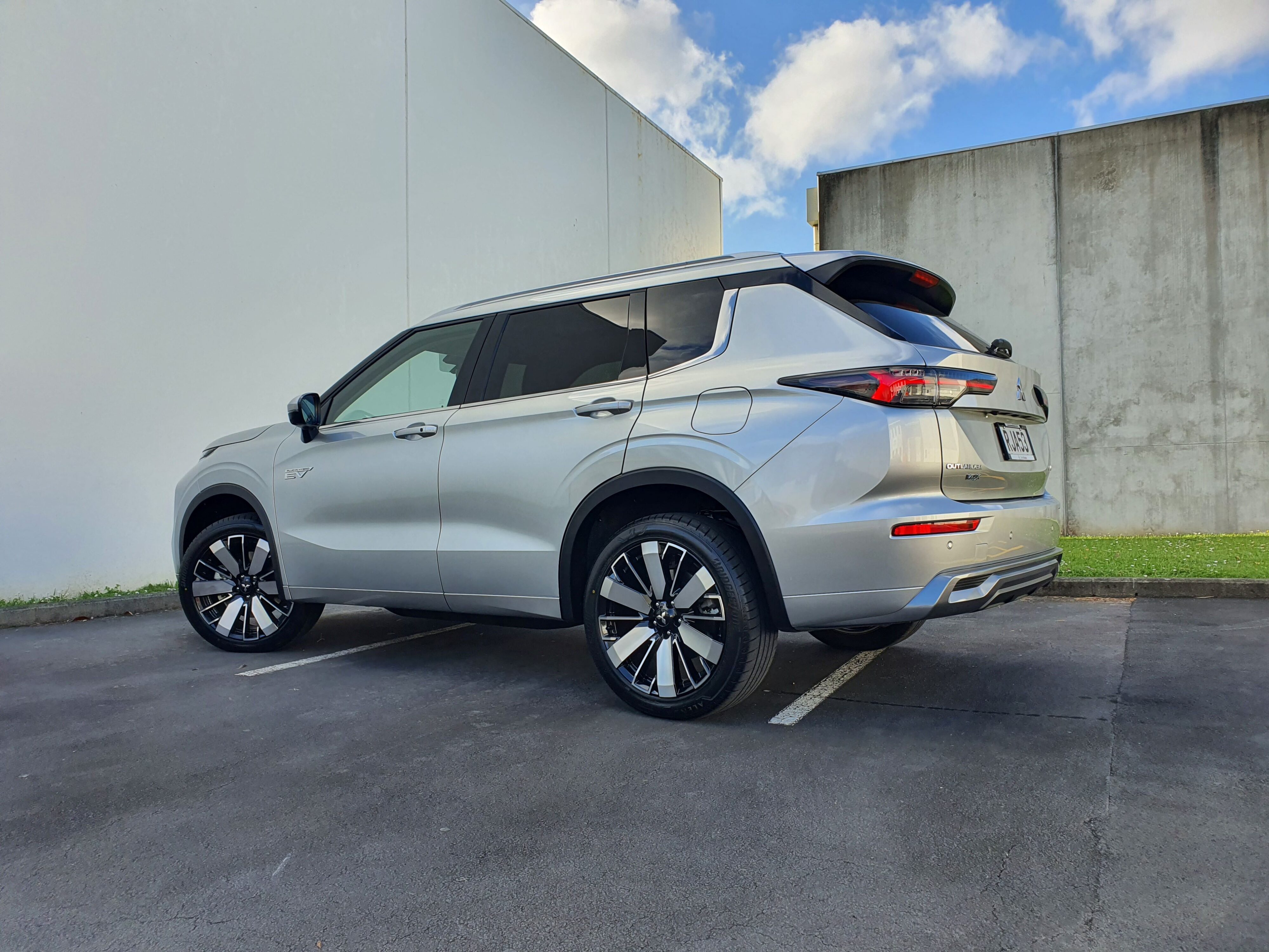 Rear three quarters view of a 2025 Mitsubishi Outlander VRX PHEV in Silver.