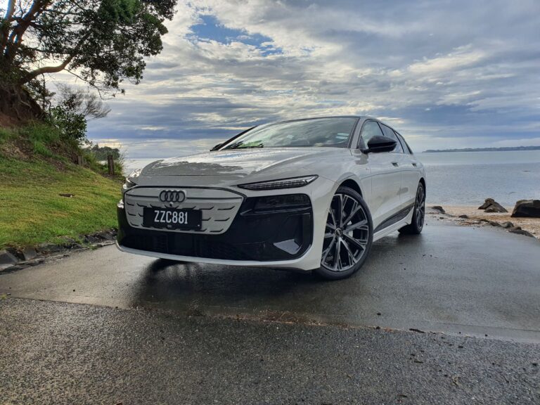 A6 - Close up of the front three quarters of an Audi A6 Avant e-tron S-Line quattro in Siam Beige with the ocean in the background.